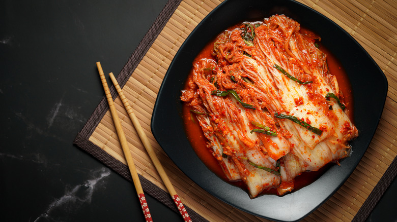 Kimchi in bowl beside chopsticks