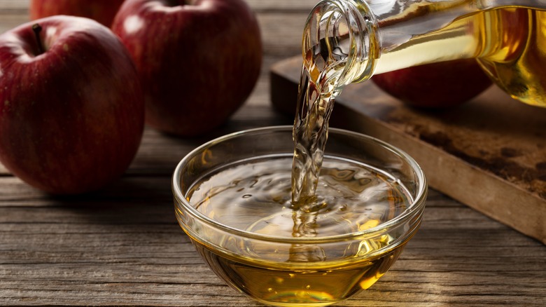 apple cider vinegar being poured into bowl