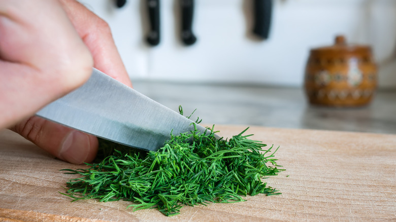 Chopping dill on cutting board