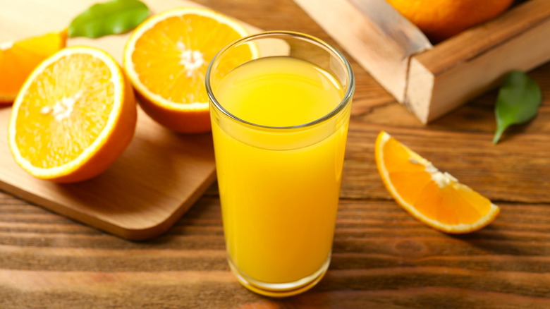 Glass of freshly squeezed orange juice on table