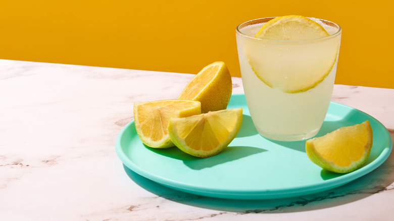 Glass of fresh lemonade on blue plate