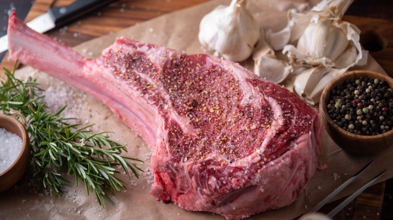 Seasoned raw tomahawk steak 