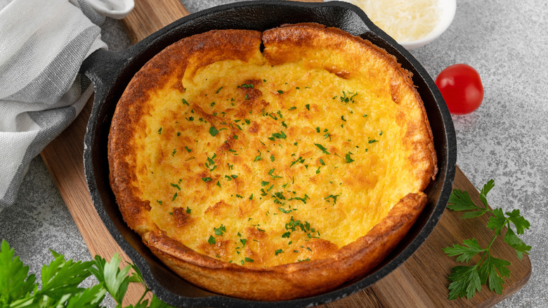 Vegan Dutch baby on counter with tomato and herbs