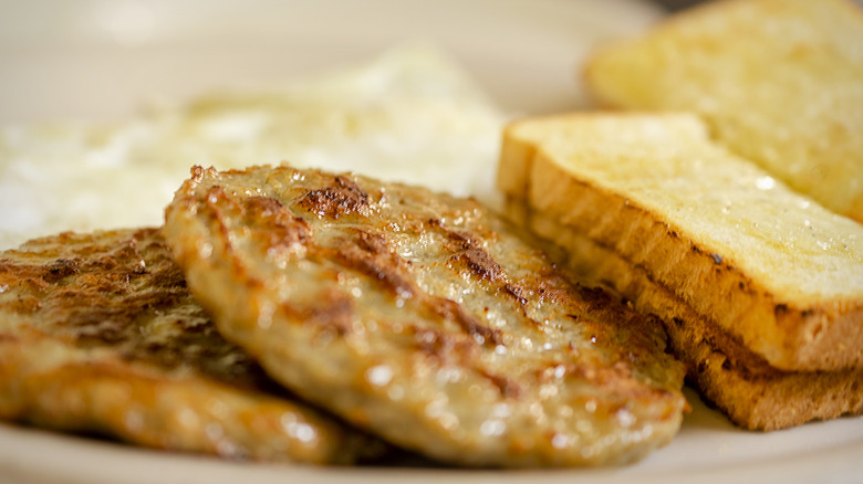 Breakfast sausage with buttered white toast on plate