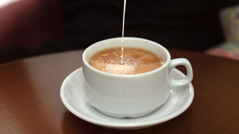 milk streaming into black tea