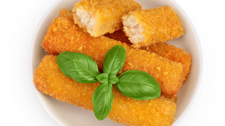 fish sticks or stick with parsley in ceramic bowl