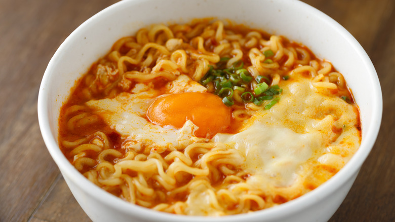 spicy instant ramen noodle with cheese and an egg