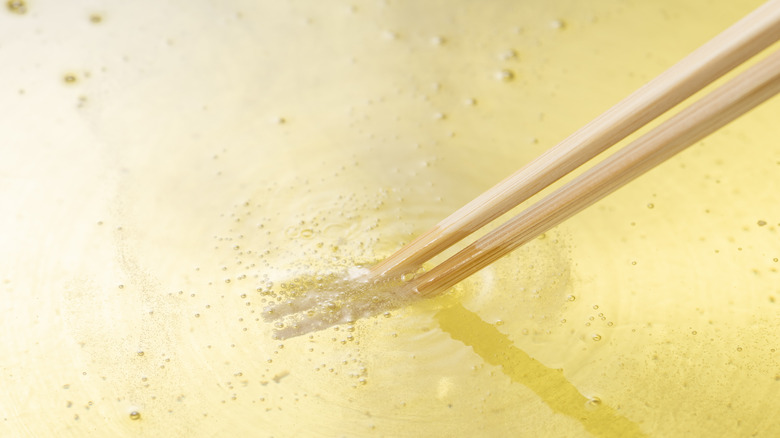 Testing oil with chopsticks