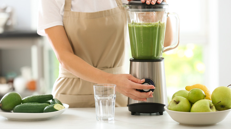 Woman making green smoothie