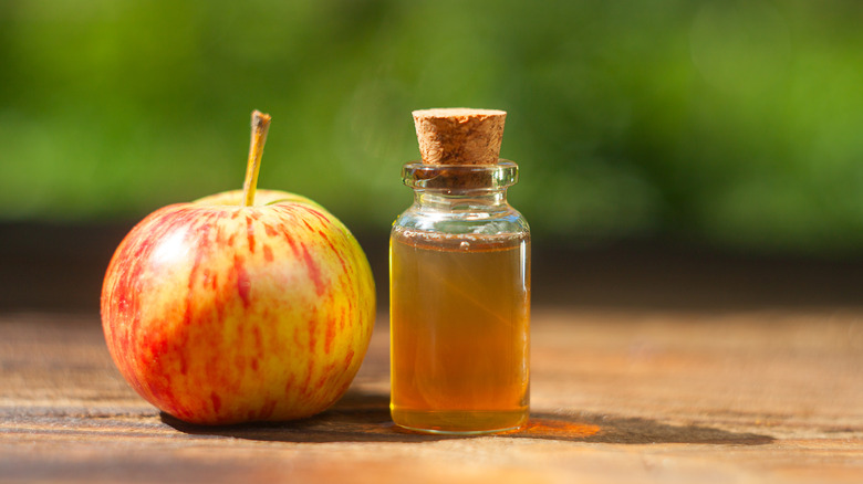 apple and small glass bottle