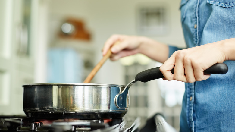 A woman cooking with a pan