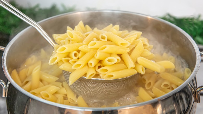 Penne pasta cooking in pot