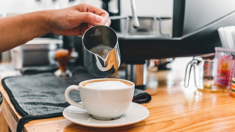 Barista pouring milk