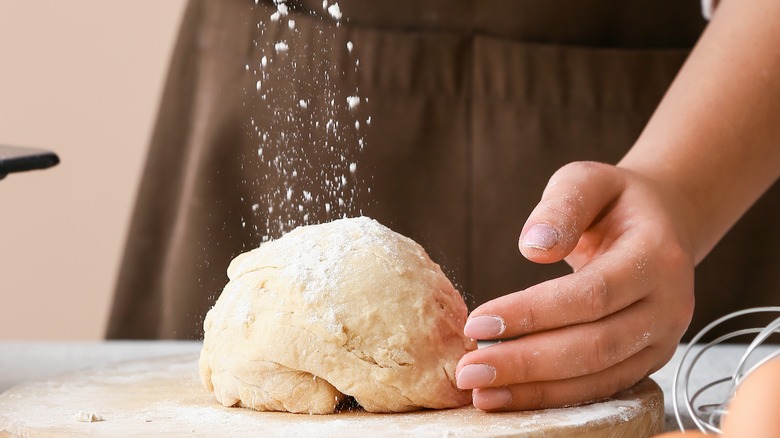 Sprinkling flour on dough