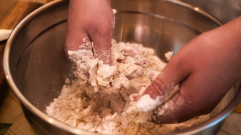 Hands mixing flour and fat