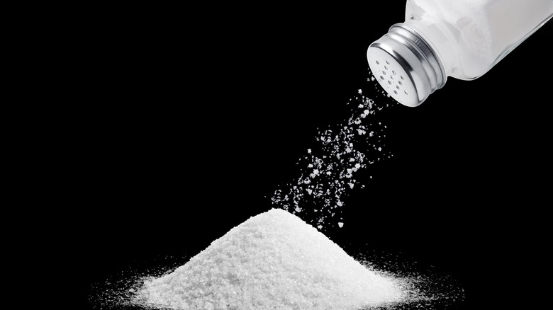 Salt sprinkling on black background