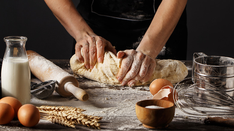 Person working dough with hands