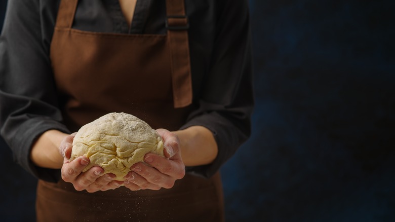 Person holding ball of pie dough