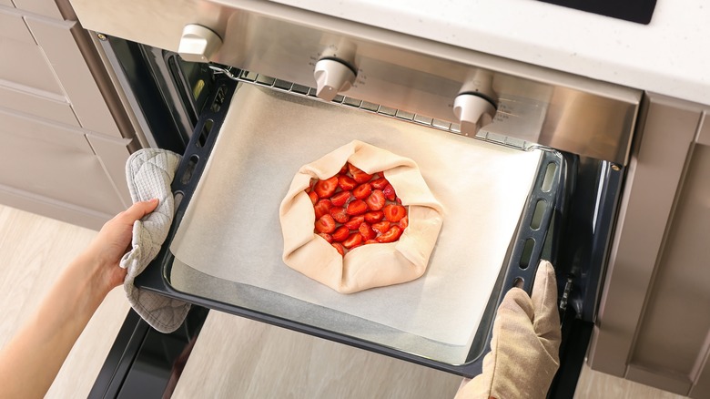 Person putting galette into oven