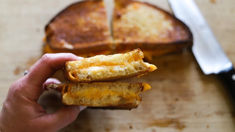 hand holding grilled cheese sandwich