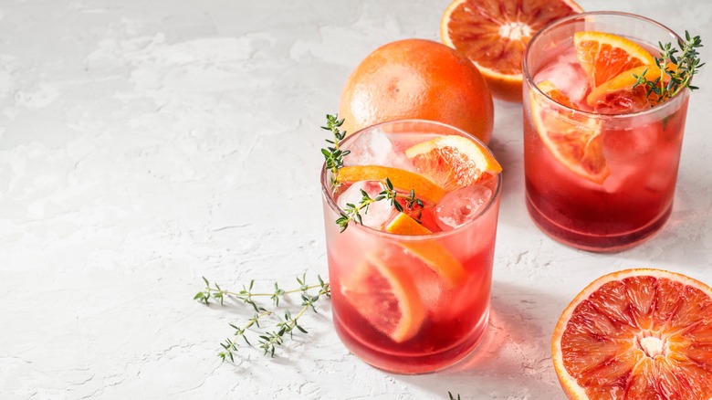red cocktail with orange garnish