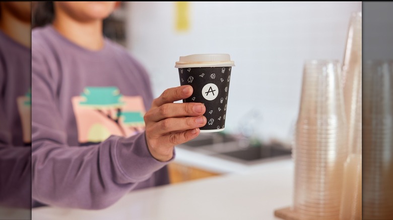 barista handing coffee over