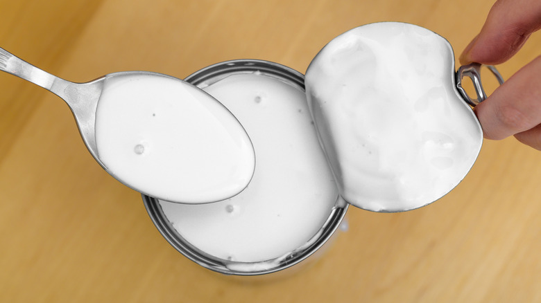 Close up of coconut milk from a can with spoon