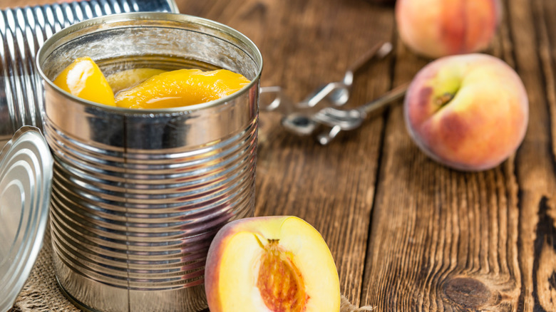 Portion of preserved peaches on wooden background