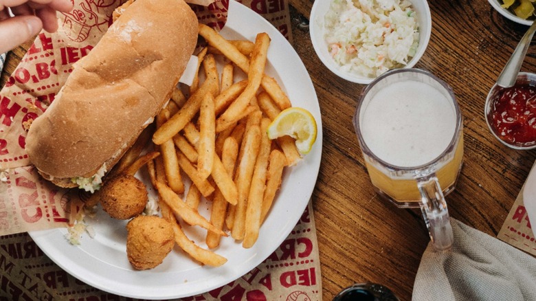 Eat My Catfish po boy with hush puppies, fries, slaw, and beer