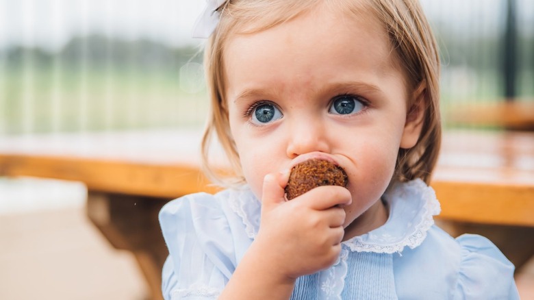 toddler eating a hush puppy