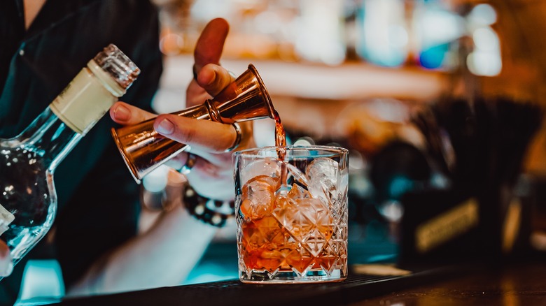 bartender adding liquor to glass