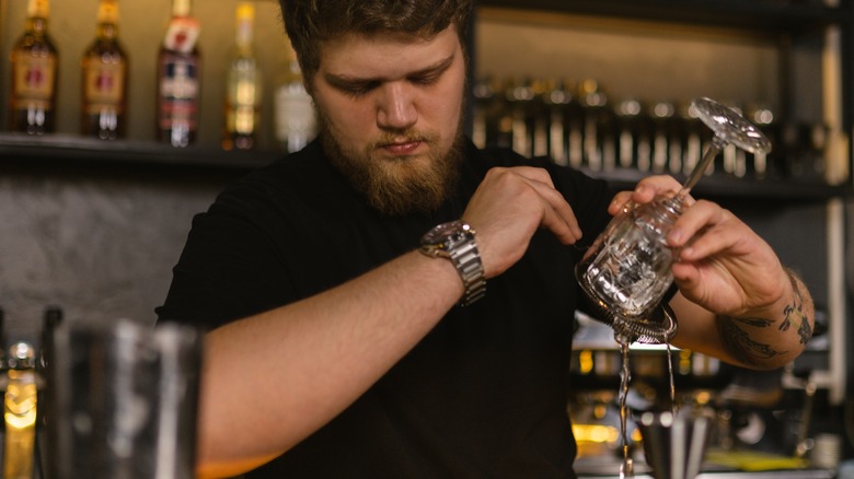 bartender rinsing cocktail glass