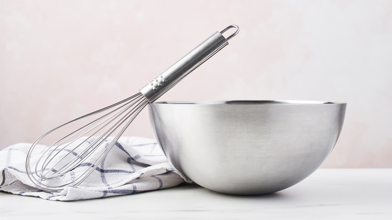 Whisk resting on metal mixing bowl 