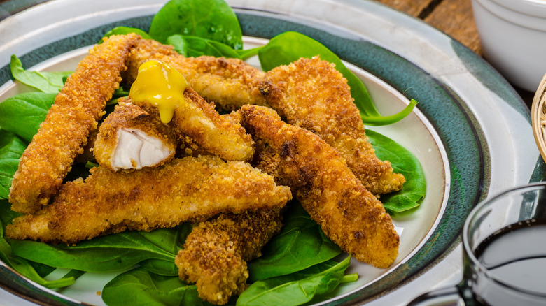 crusted chicken strips on spinach