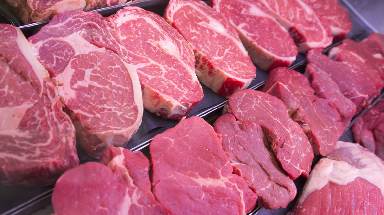 Raw steaks on black shelf 