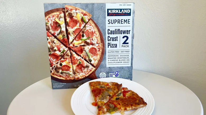 Supreme cauliflower crust pizza box and slices on table