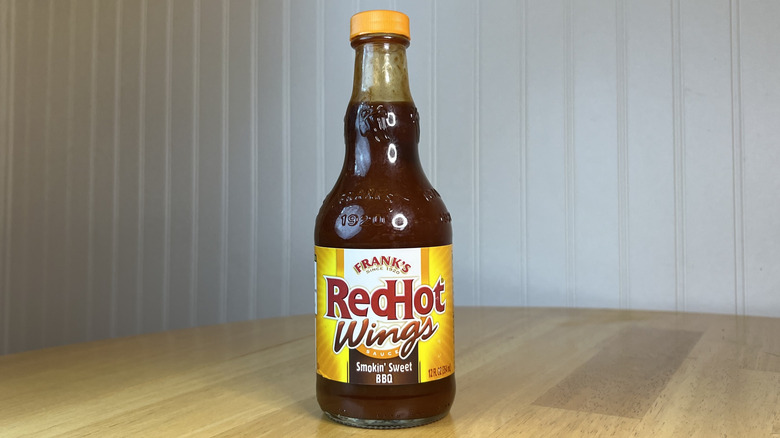 Bottle of Frank's RedHot Wings Smokin' Sweet BBQ Sauce on wooden table