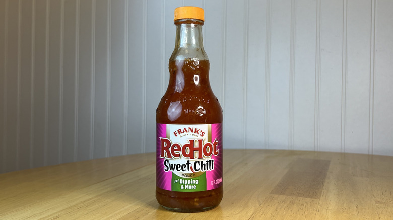 Bottle of Frank's RedHot Sweet Chili Sauce on wooden table