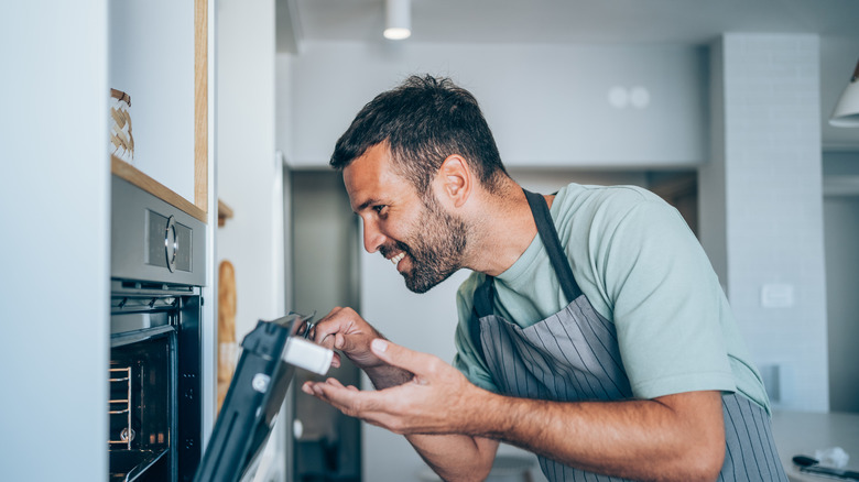 Happy person looking into oven