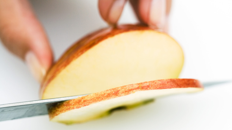 Person slicing apples with a knife