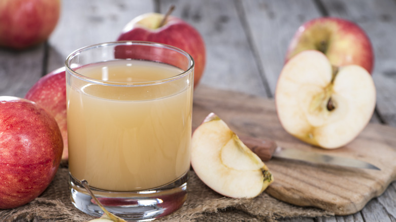 Glass of apple juice with sliced apples