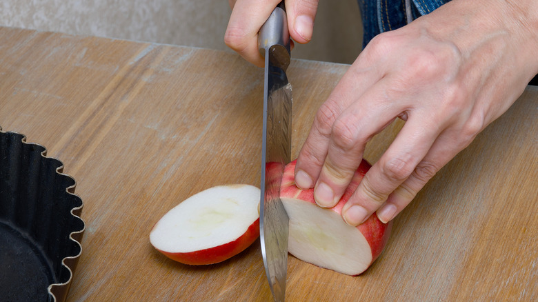 Person chopping up apples with a sharp knife