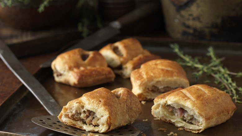 Sausage rolls with spatula and pan