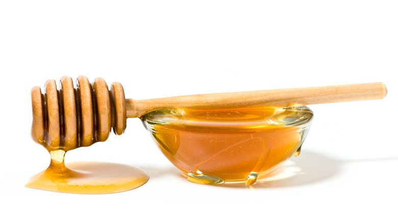 Honey with spoon on white
