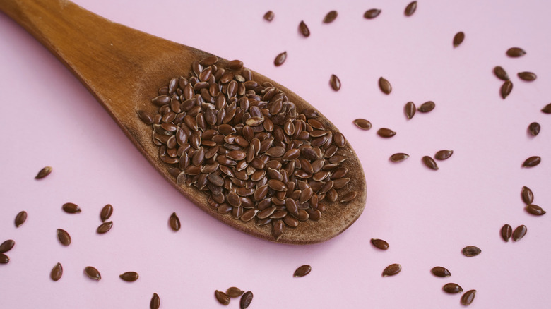 flax seed on spoon on pink background