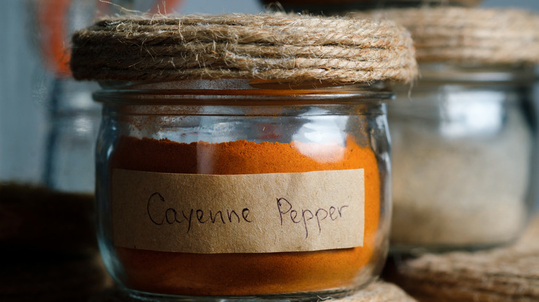 Cayenne pepper in a glass jar with a jute-wrapped lid