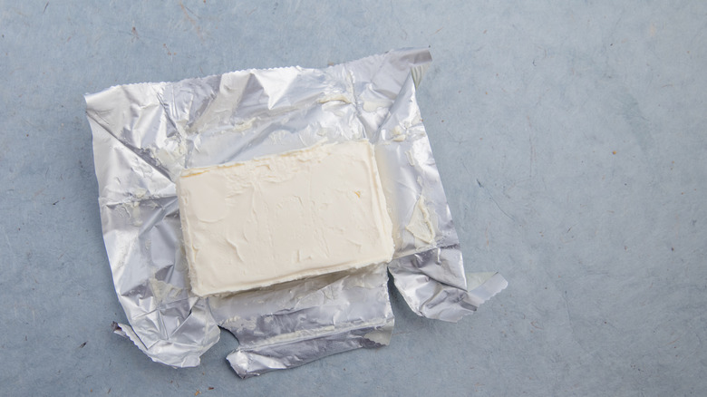 Cream cheese block sitting on top of opened foil packet