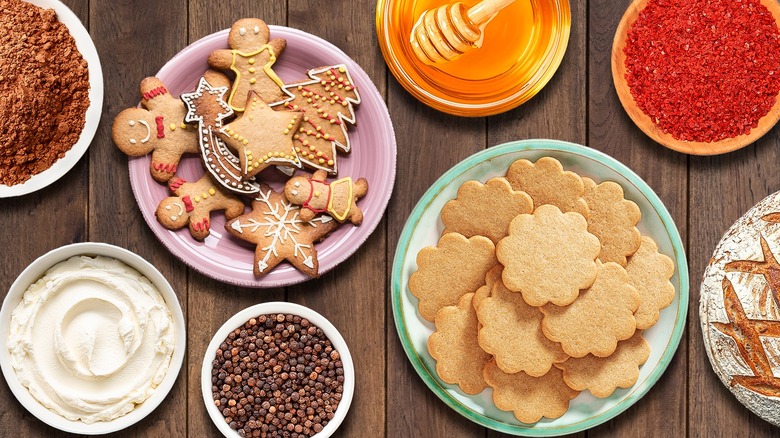 gingerbread cookies and ingredients laid out in plates on wooden table