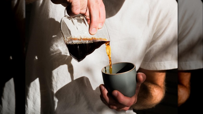 Man pouring espresso into cup