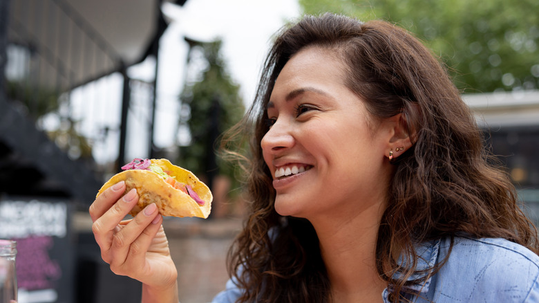 Woman eating taco